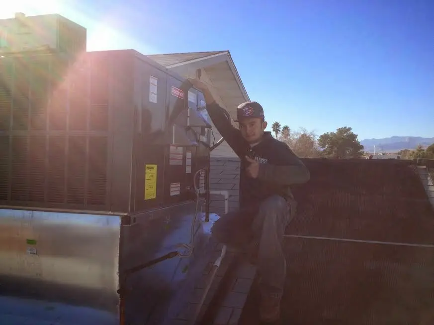 HVAC technician performing AC Tune-Up on a rooftop unit in Lewiston